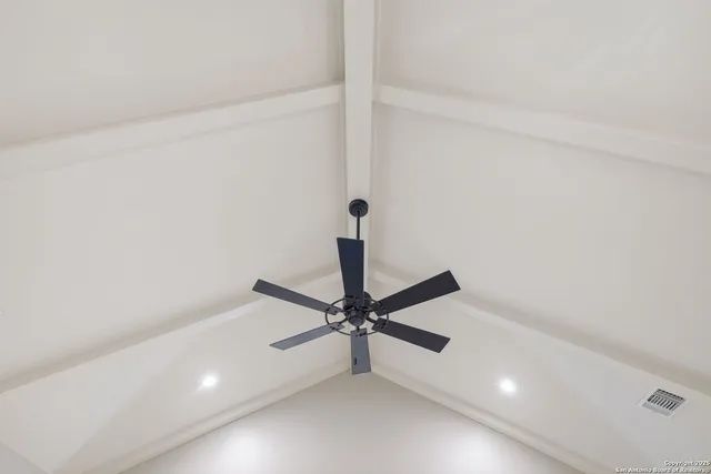 a view of a room with a ceiling fan and wooden floor