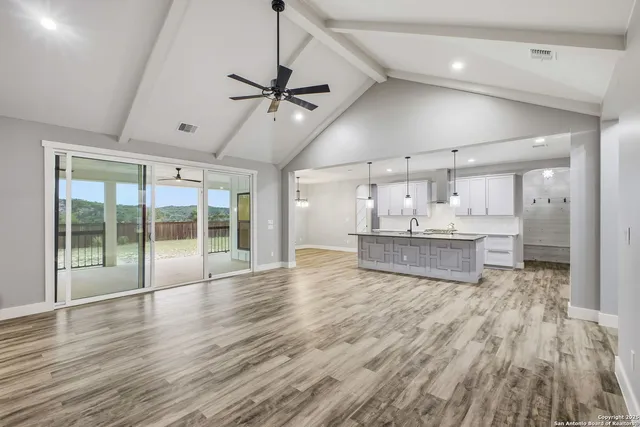 a view of a kitchen with wooden floor and a window