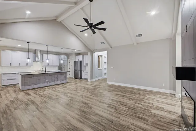 a large kitchen with stainless steel appliances kitchen island a refrigerator oven a sink with dishwasher and white cabinets