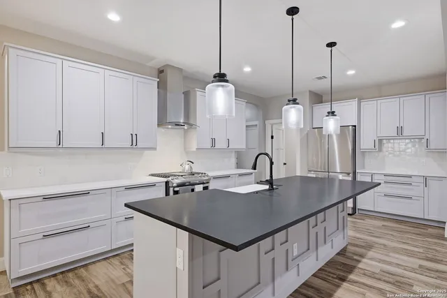 a kitchen with stainless steel appliances granite countertop a sink a counter space and cabinets