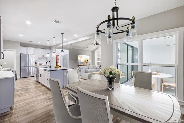 a view of a dining room and livingroom with furniture wooden floor a chandelier