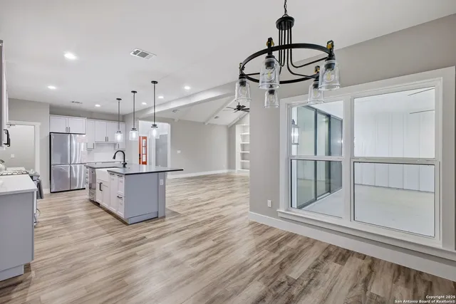 a view of a kitchen with refrigerator and wooden floor