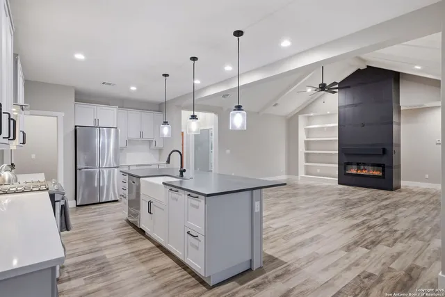 a kitchen with stainless steel appliances granite countertop a sink a refrigerator and a stove