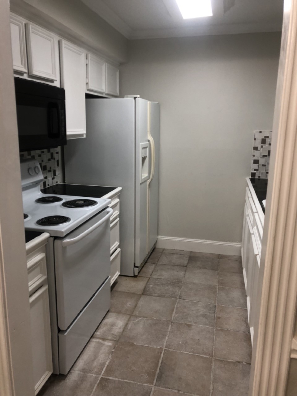 4641 Wild Indigo Street, Unit 439 Houston, TX 77027 - Photo 4 of 10 a kitchen with a refrigerator stove and microwave