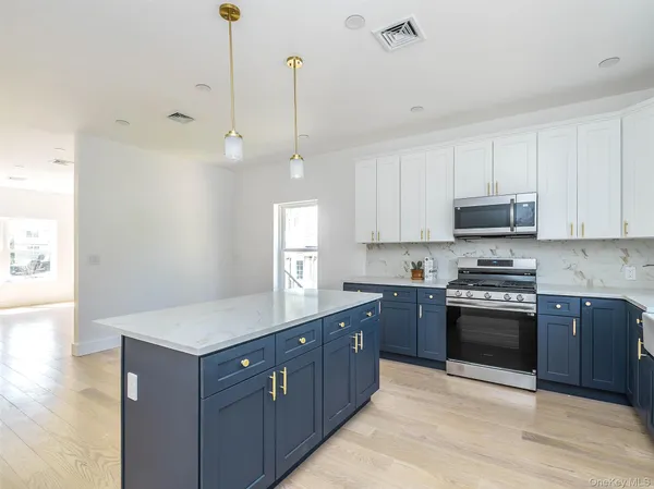a kitchen with stainless steel appliances granite countertop a stove a sink and a wooden floors