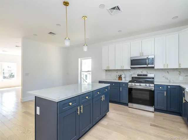 a kitchen with stainless steel appliances granite countertop a stove a sink and a wooden floors