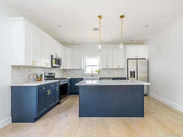 a large kitchen with stainless steel appliances granite countertop a stove a sink dishwasher and a wooden cabinets