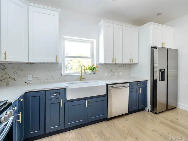 a kitchen with stainless steel appliances granite countertop a sink a refrigerator and cabinets