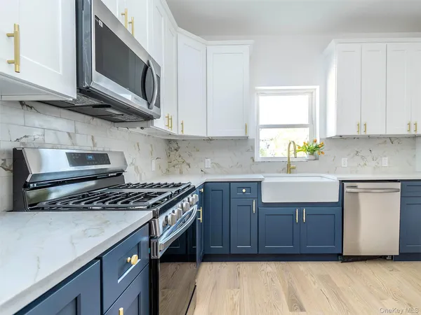 a kitchen with stainless steel appliances granite countertop a stove a sink and a microwave