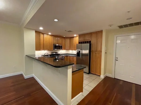 a kitchen with stainless steel appliances granite countertop a refrigerator a sink a stove and oven