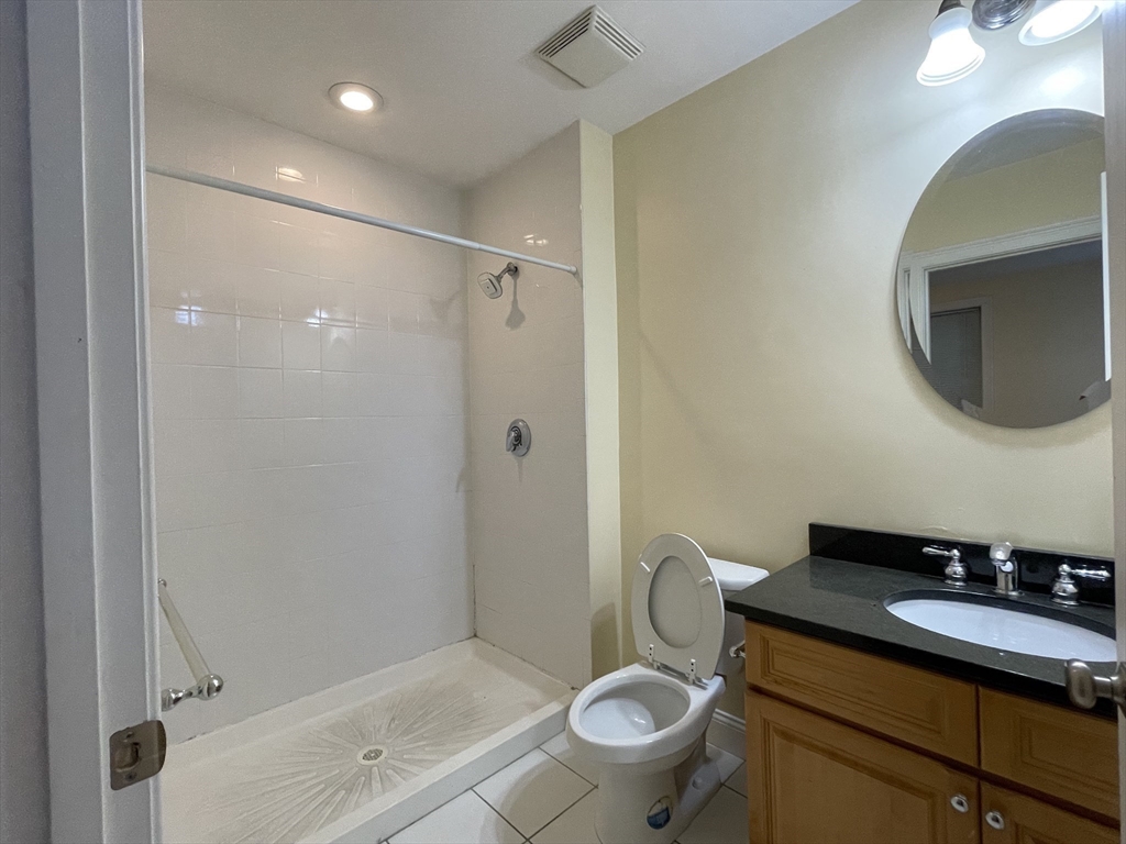 81-87 Fairmount Avenue, Unit 8 Boston, MA 02136 - Photo 7 of 12 a bathroom with a granite countertop sink mirror vanity and toilet