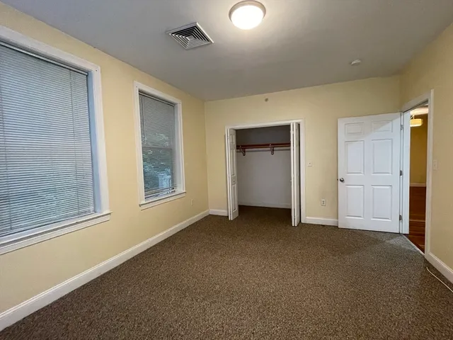 an empty room with closet and windows