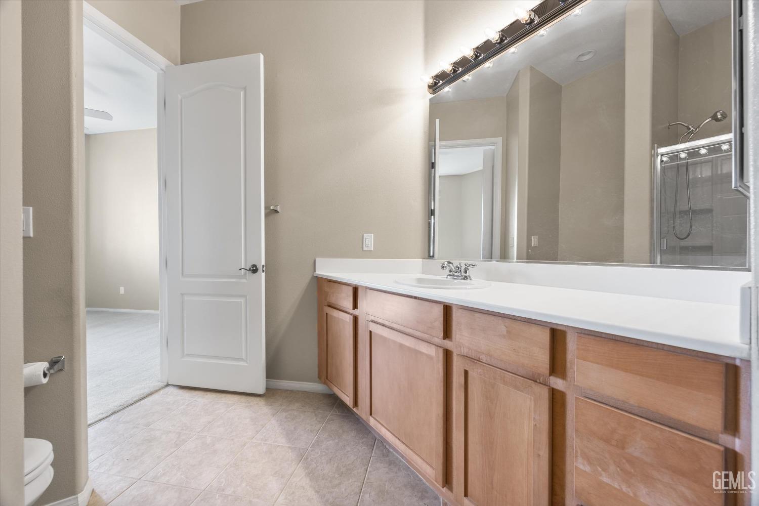 Undisclosed Address Bakersfield, CA 93306 - Photo 25 of 35 a bathroom with a double vanity sink and mirror