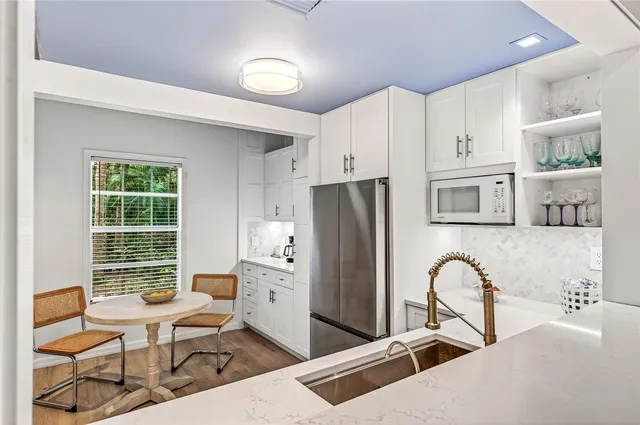 a kitchen with stainless steel appliances granite countertop a refrigerator and a stove top oven