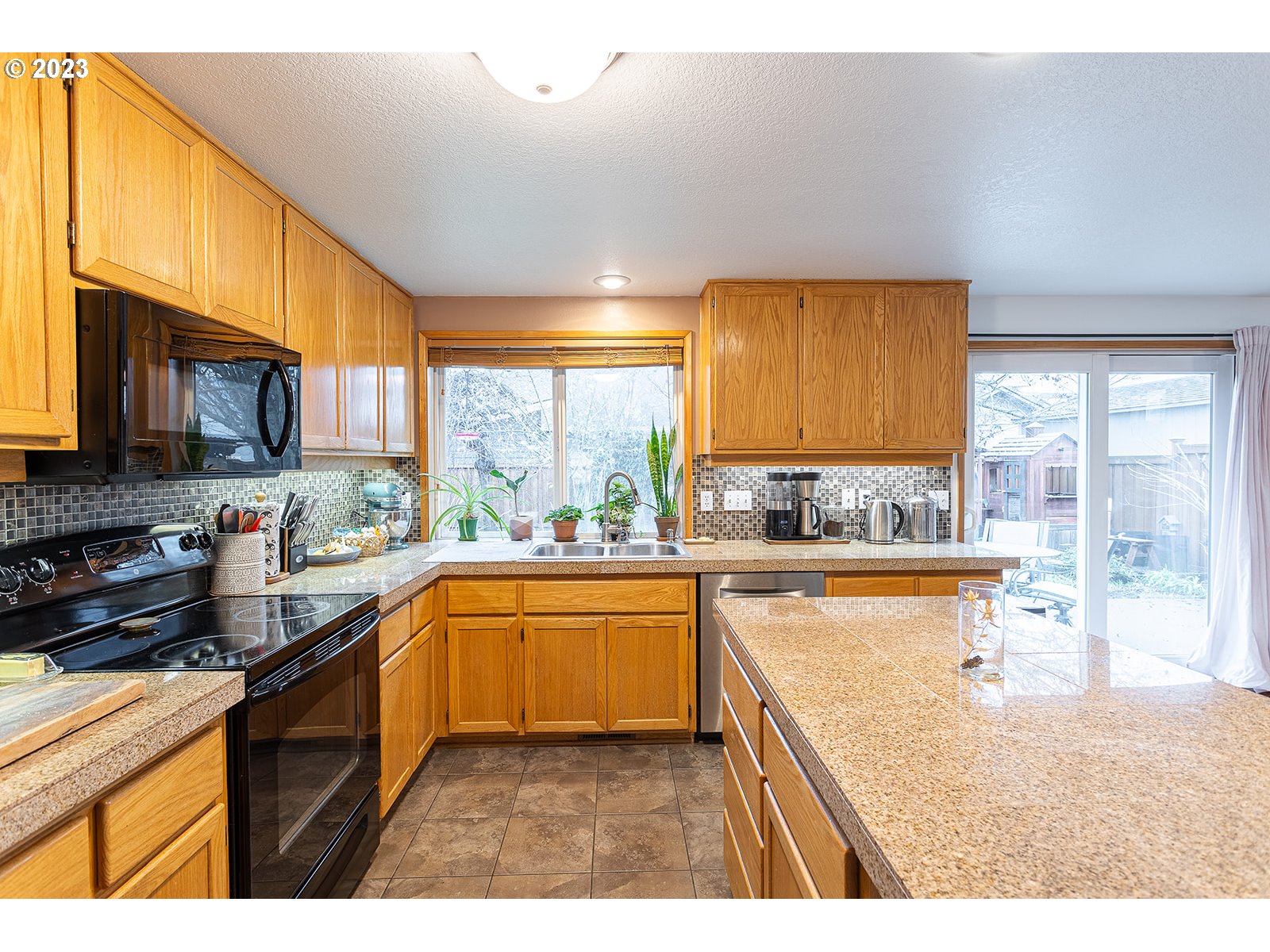 4010 Torrington Avenue Eugene, OR 97404 - Photo 9 of 35 a kitchen with stainless steel appliances granite countertop a stove a sink and a microwave