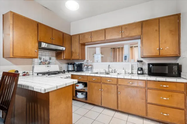a kitchen with stainless steel appliances granite countertop a sink stove and cabinets