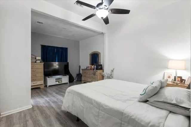 a bedroom with a bed and a flat tv screen on dresser