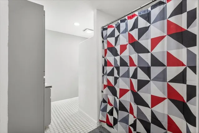 a area with white walls and a shower curtain