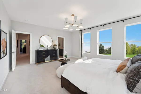 a bed room with a bed mirror and a chandelier