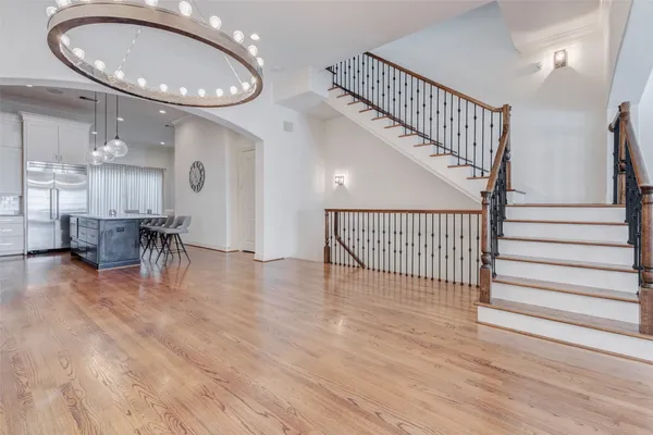 a view of a living room and chandelier with wooden floor and staircase