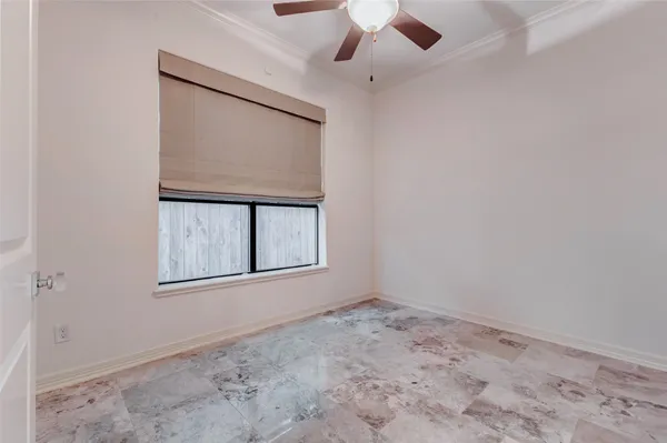 an empty room with a window and a ceiling fan
