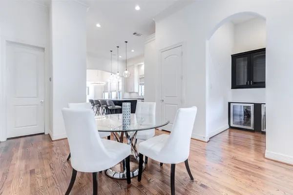 a view of an empty room with wooden floor and a chandelier