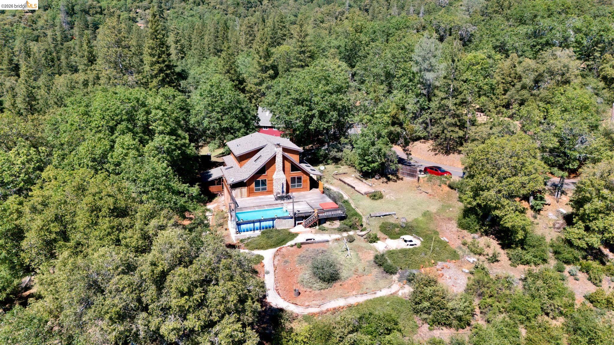 14799 Big Hill Road Sonora, CA 95370 - Photo 3 of 60 View of subject property featuring a heavily wooded area and a pool area