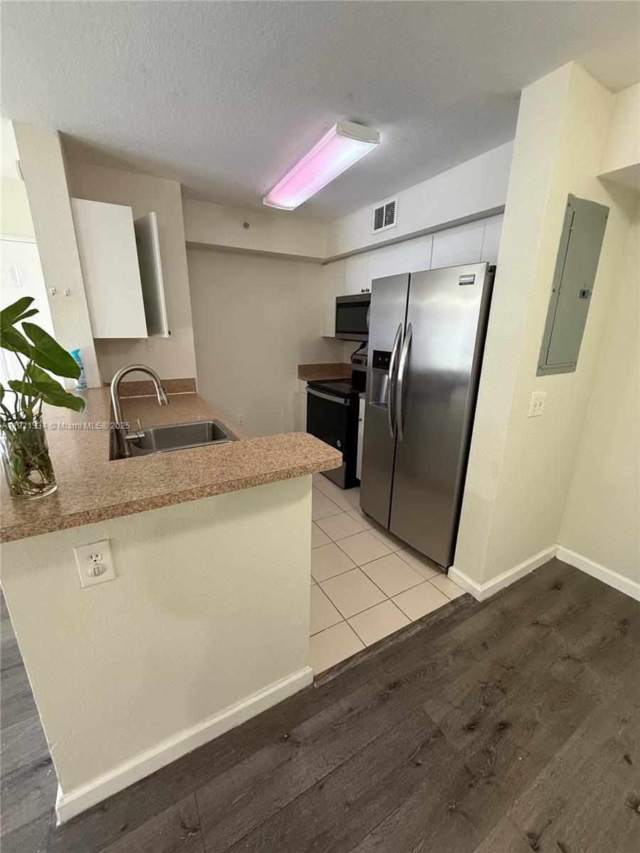 15422 Southwest 284th Street, Unit 7202 Homestead, FL 33033 - Photo 5 of 13 a kitchen with granite countertop a refrigerator and a sink
