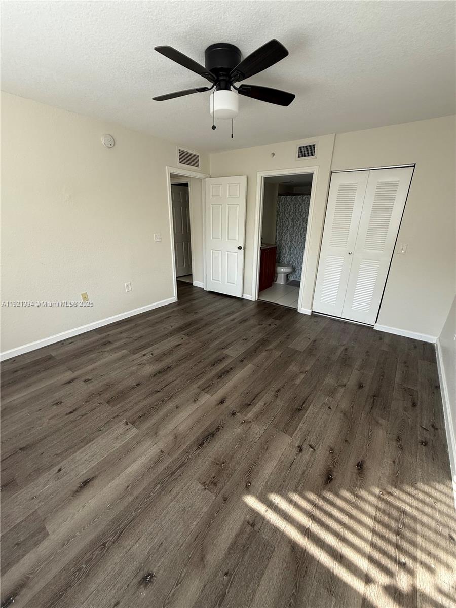 15422 Southwest 284th Street, Unit 7202 Homestead, FL 33033 - Photo 6 of 13 an empty room with wooden floor and ceiling fan