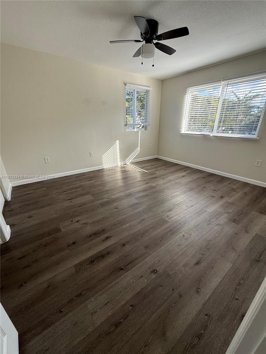 15422 Southwest 284th Street, Unit 7202 Homestead, FL 33033 - Photo 10 of 13 wooden floor in an empty room with a window