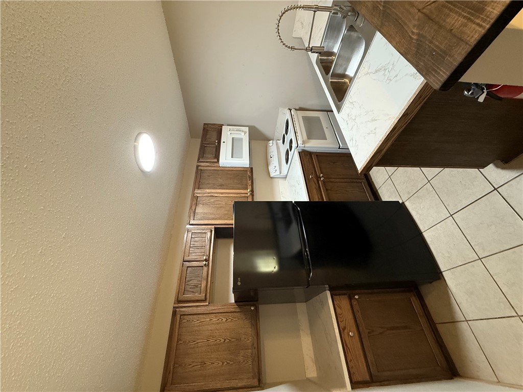 2000 Kazmeier, Unit 11 Bryan, TX 77802 - Photo 7 of 11 a kitchen with a stove a sink and a refrigerator