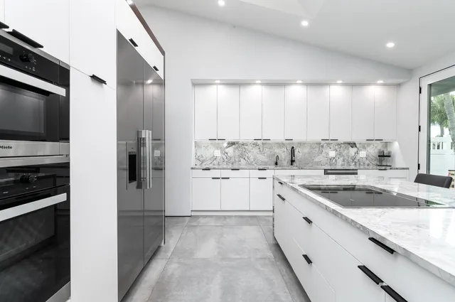 a kitchen with granite countertop a sink stainless steel appliances and cabinets