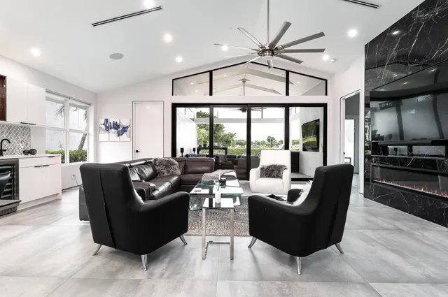 a living room with furniture ceiling fan and a large window