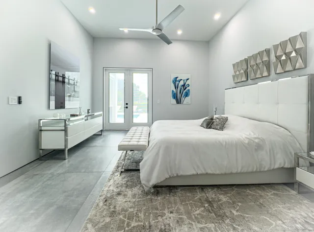 a bedroom with a balcony a bed and ceiling fan