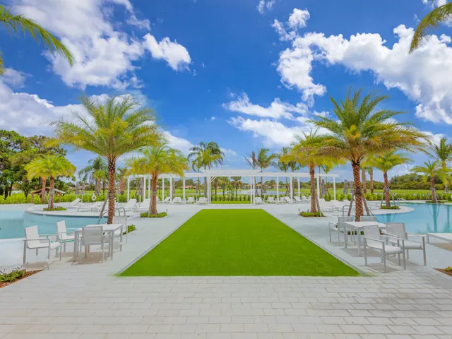 a view of a park with a slide and large trees