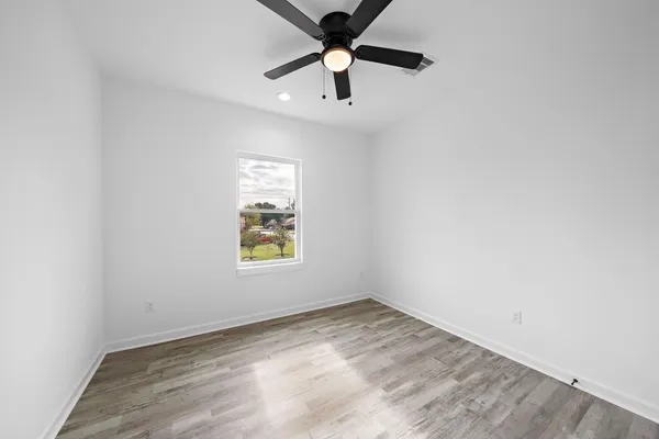 an empty room with a window and a ceiling fan