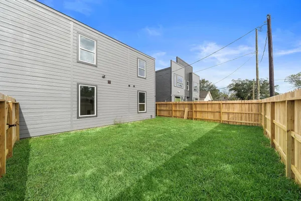 a view of a backyard with floor to ceiling window and wooden fence