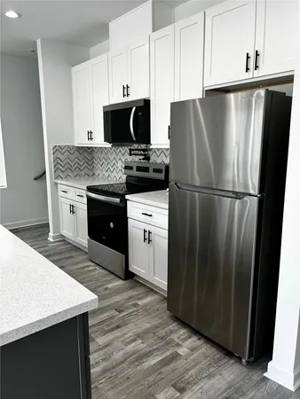 a kitchen with granite countertop a refrigerator stove and sink