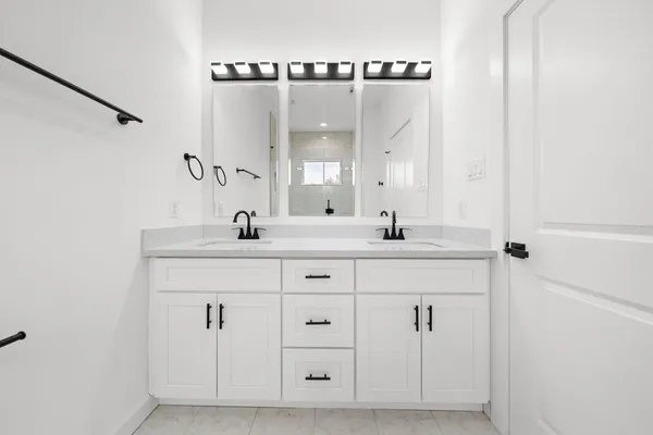 a bathroom with a double vanity sink and a mirror