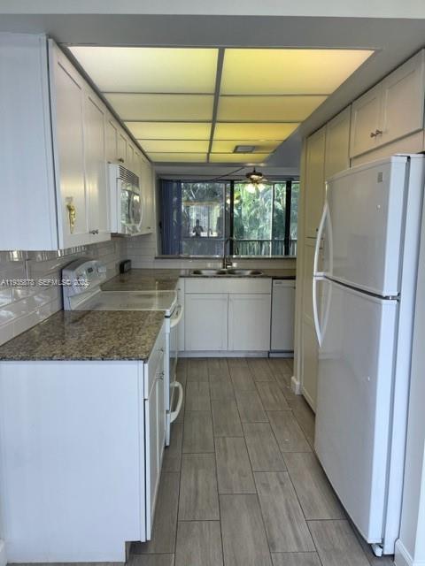 2931 Southwest 87th Terrace, Unit 1923 Davie, FL 33328 - Photo 5 of 15 a kitchen with stainless steel appliances granite countertop a refrigerator a sink dishwasher a stove with white cabinets and wooden floor