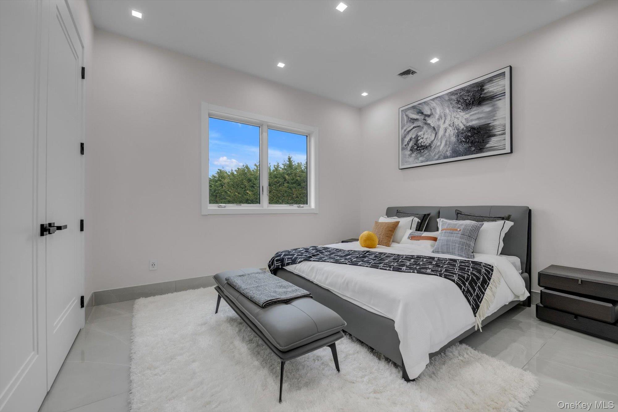 190 Curtis Road Woodmere, NY 11598 - Photo 16 of 46 a spacious bedroom with a bed and a painting on the wall