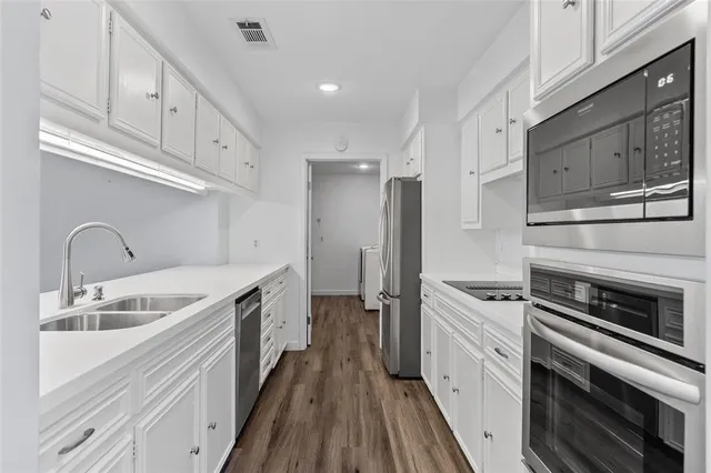 a kitchen with stainless steel appliances granite countertop a sink and cabinets
