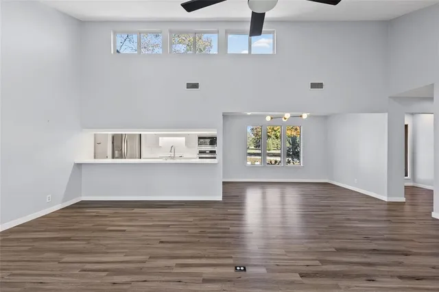 a view of an empty room with window and wooden floor