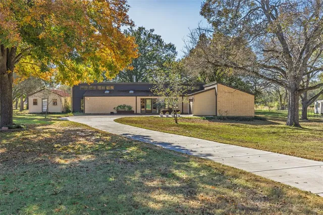 a view of house with backyard and tree
