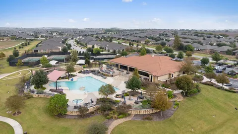 a kitchen with stainless steel appliances granite countertop a dining table chairs refrigerator and microwave