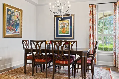 a living room with furniture kitchen view and a chandelier