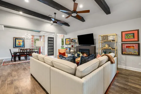 a living room with furniture a flat screen tv and a fireplace
