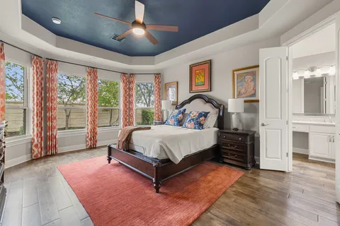 a bed sitting in a spacious bedroom next to a window
