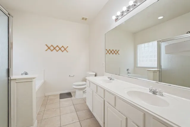 a spacious bathroom with a sink a toilet and a mirror