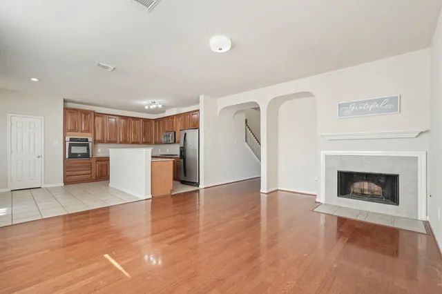 a view of a kitchen with a sink refrigerator and a fireplace